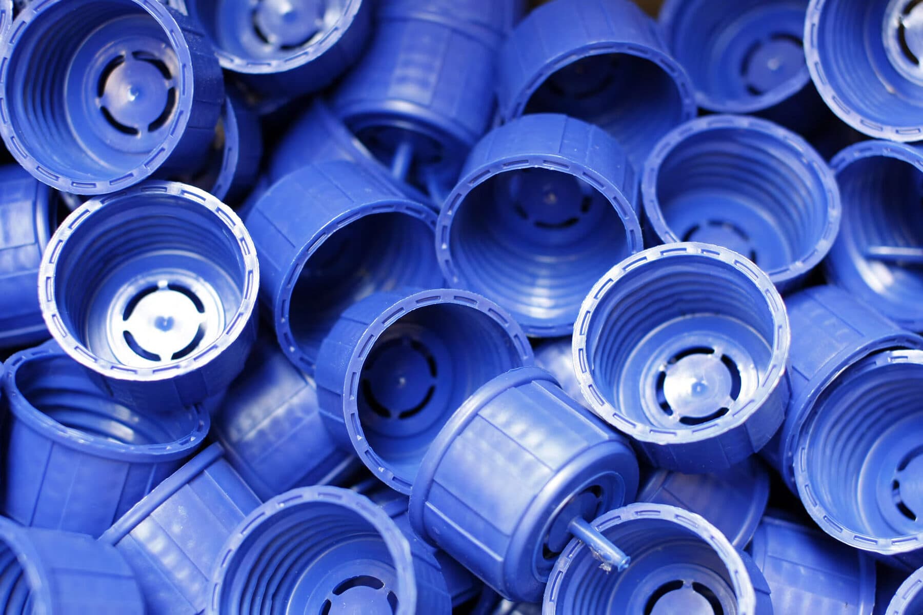 A pile of blue injection-moulded HDPE caps