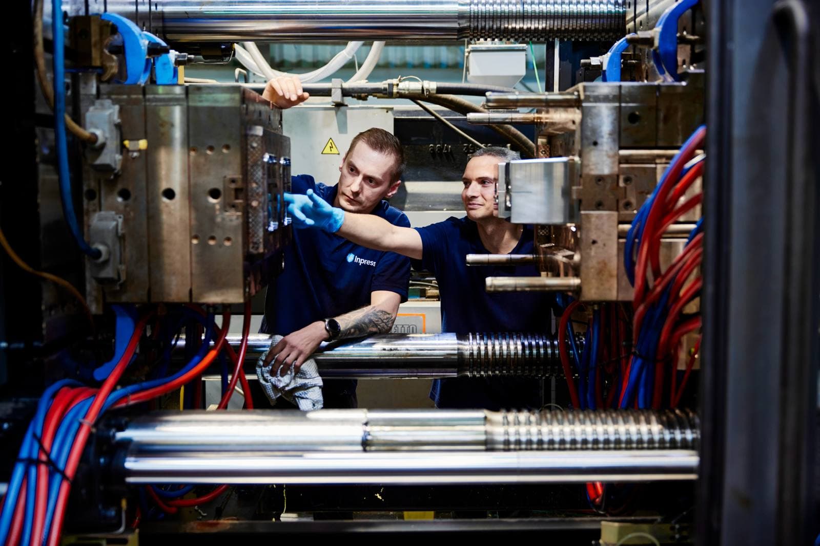 Two setters working inside an injection moulding machine