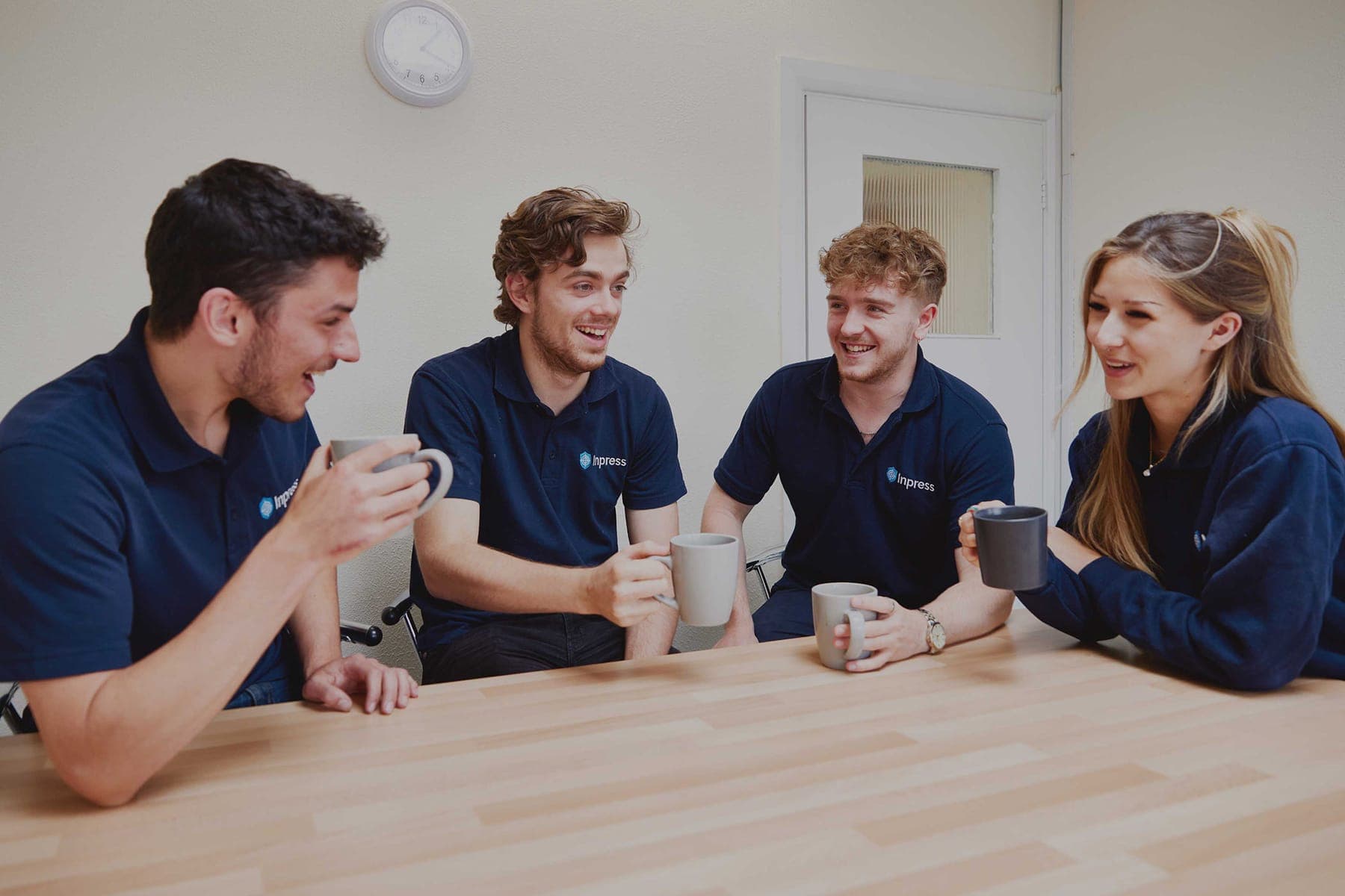 Members of the Inpress team talking over coffee